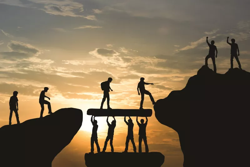 people silhouettes building bridges