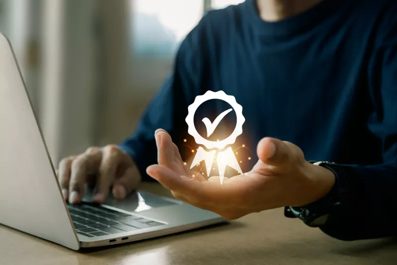 man sitting in front of computer with visualized checkbox for compliance or guarantee