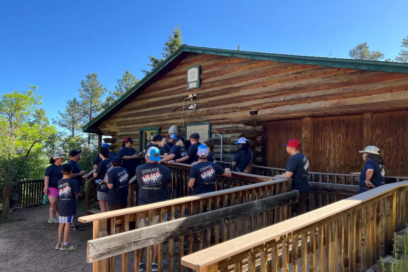 Group of workers in front of cabin installing equipment