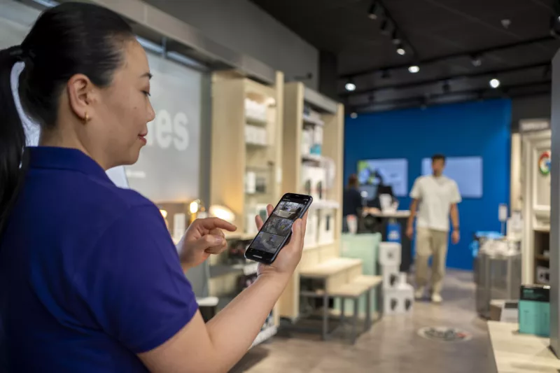 Woman looking at phone with ACS Edge in a retail store