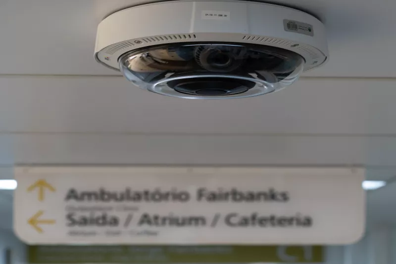 Ceiling camera in foreground with hospital sign in background