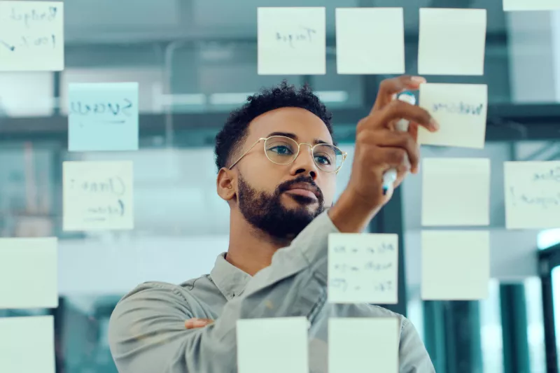 man_brainstorming_post-it_notes_glass_wall_2210_hi.jpg