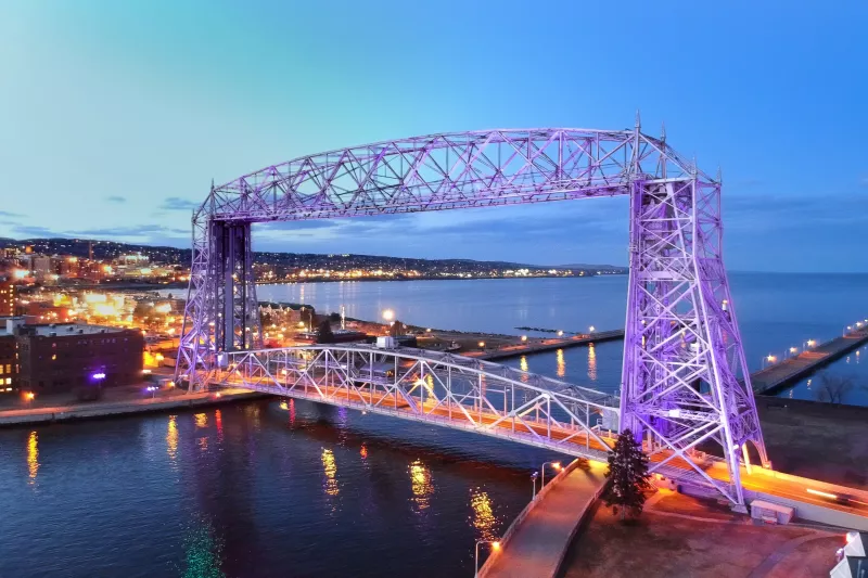 Aerial lift bridge in Duluth, MN at dusk with purple lights
