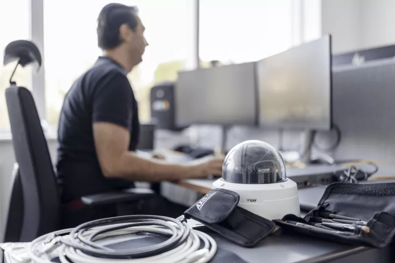 Person sitting by their desk with a camera in focus