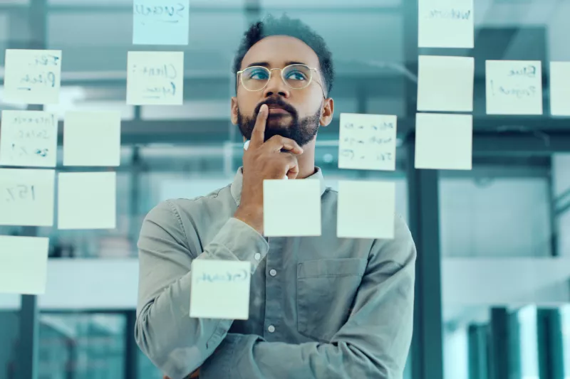 businessman brainstorming in office, looking at postits