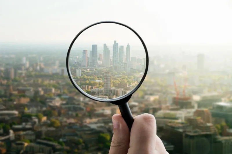 Magnifying glass with city scape inside