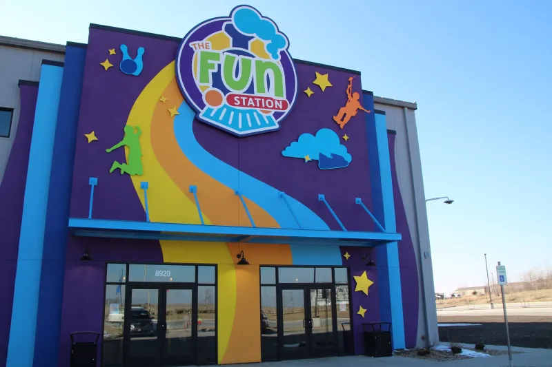 Colorful "The Fun Station" building with playful decor and rainbow-like stripes.