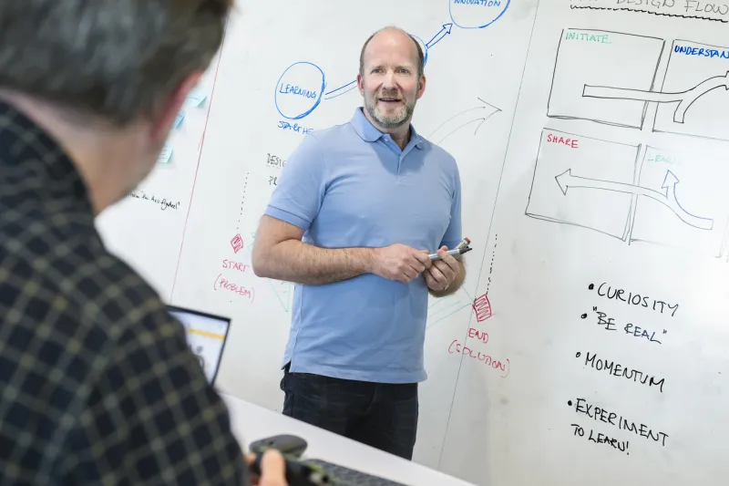 Thomas Ekdahl is standing infront of a whiteboard 