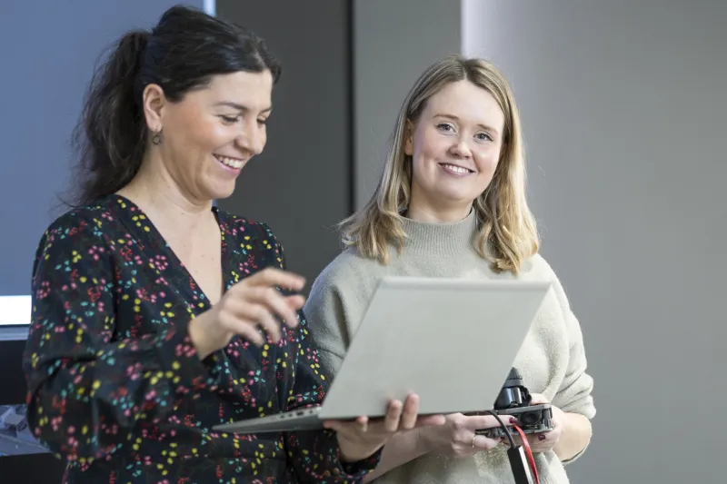 two people in front of laptop