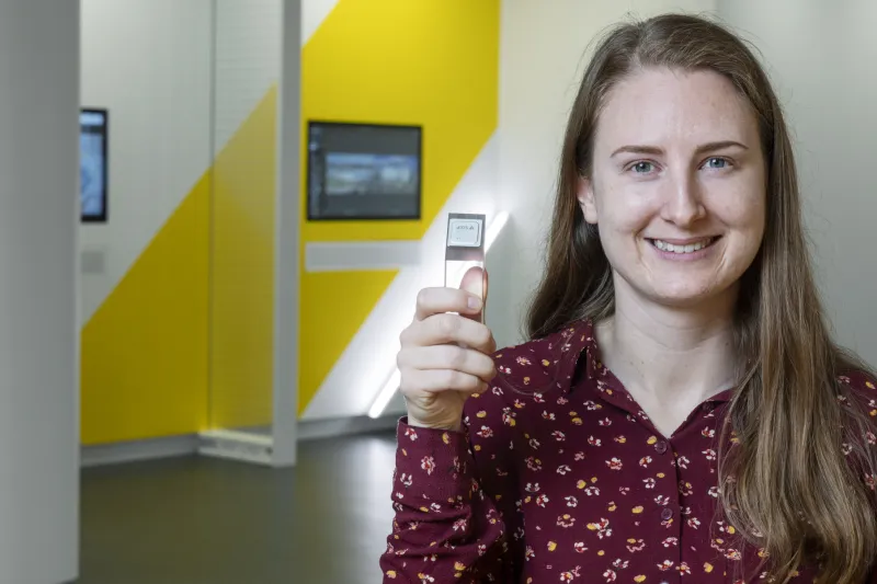 Malin Heyden holding up a ARTPEC chip