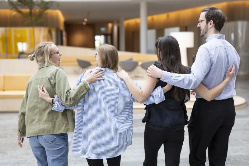 Stina Stadig, Ramona Berger, Rebecca Jonsson and Markus Richter standing in a line with their arms around each other's shoulders 