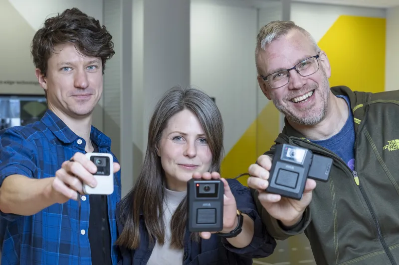Johanna, Filip and Fredrik holding up bodyworn cameras 