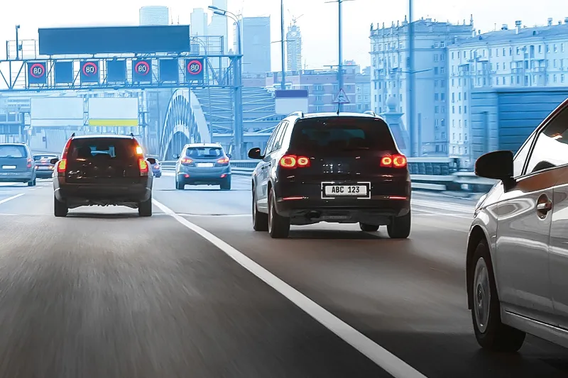 Back view of cars driving in the highway. Their license plates can be seen clearly.