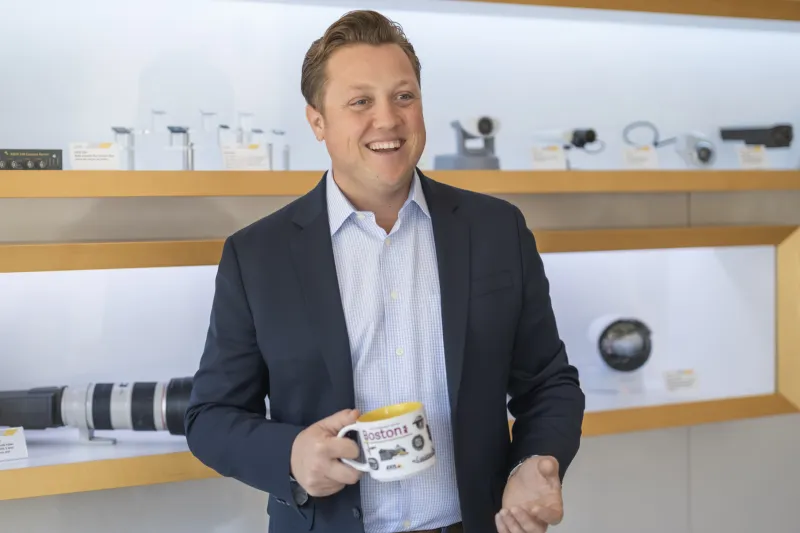 Nick Biagioni holding a cup and smiling 
