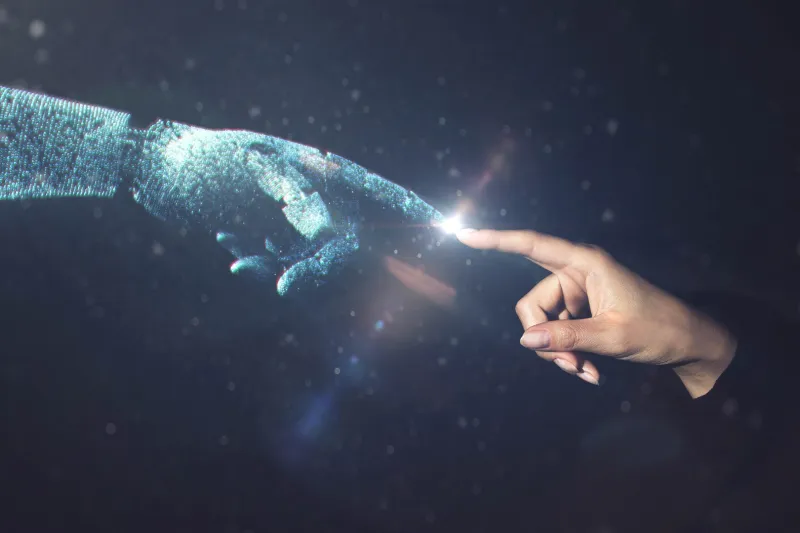 Human hand touching ai robot hand