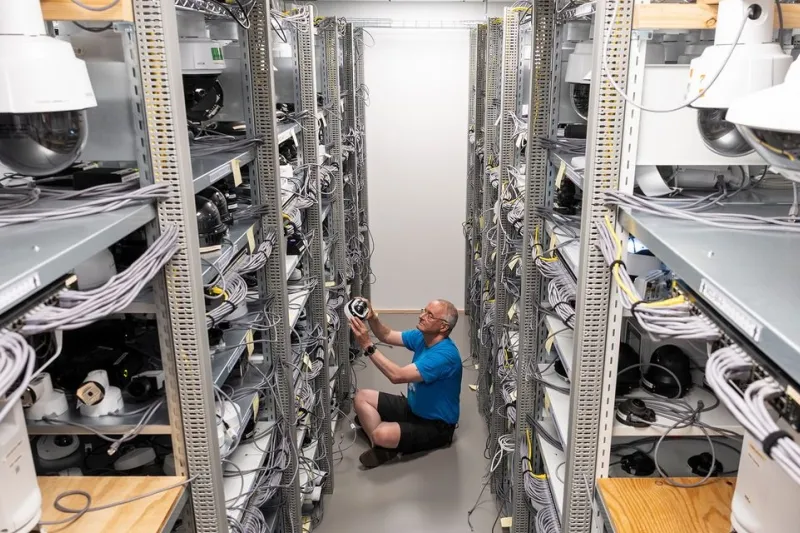 Person sitting on floor looking at cameras in a lab