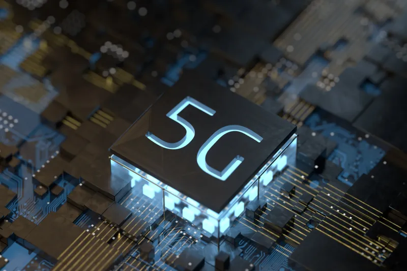 A 5G chip in development with glowing light on the board.