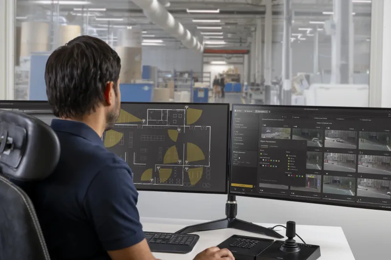 Man sitting in front of two screens.