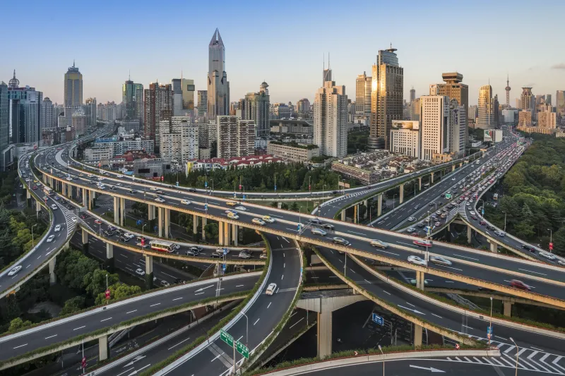 Highway roads in between and around a city with high skyscrapers and smaller buildings. 