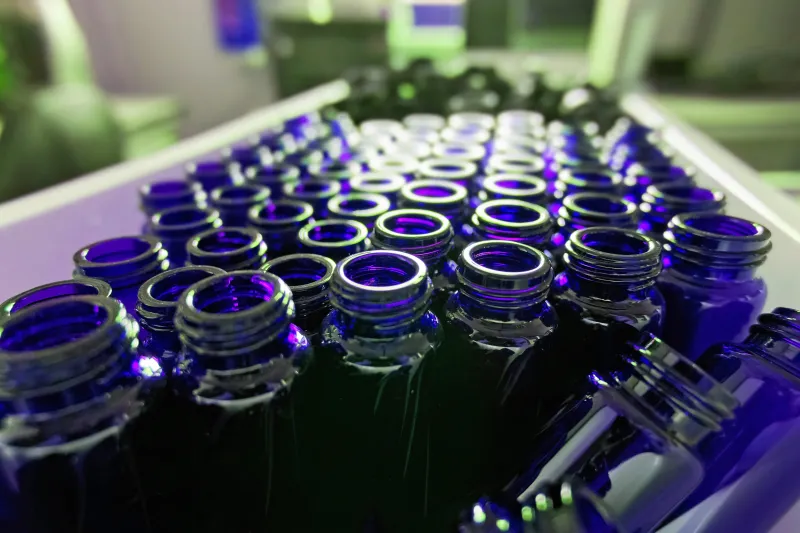Conveyer belt filled with chemical vial bottles.