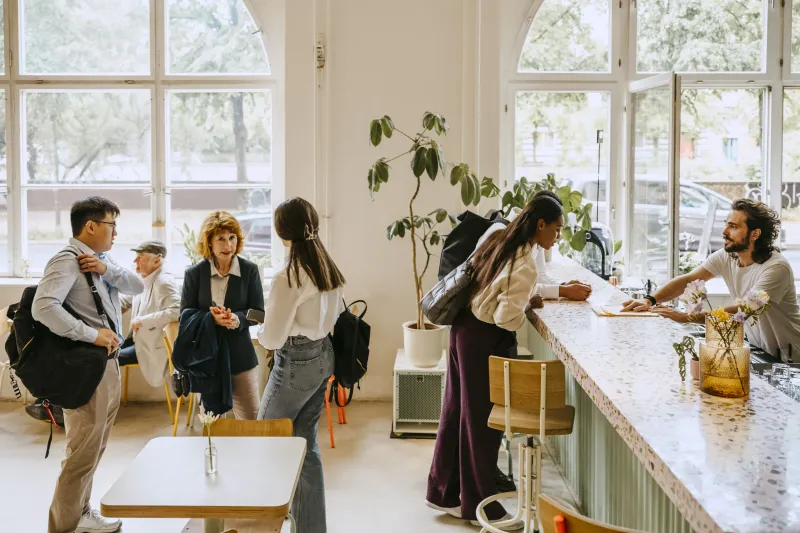 Customers standing in a queue by the restaurant counter.