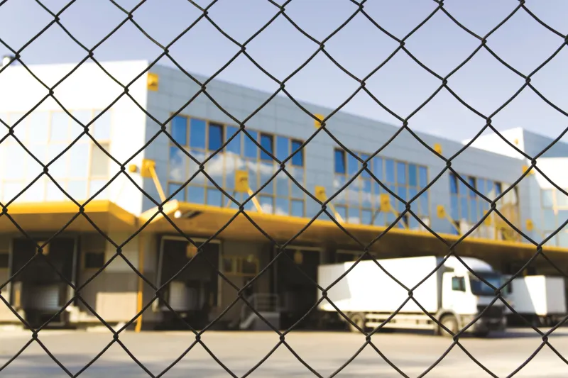 Fenced warehouse with loading docks outside.