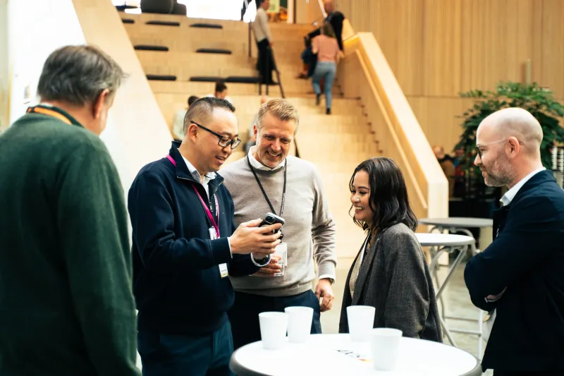 Axis colleagues standing together in an open office area at the Axis headquarters in Lund.