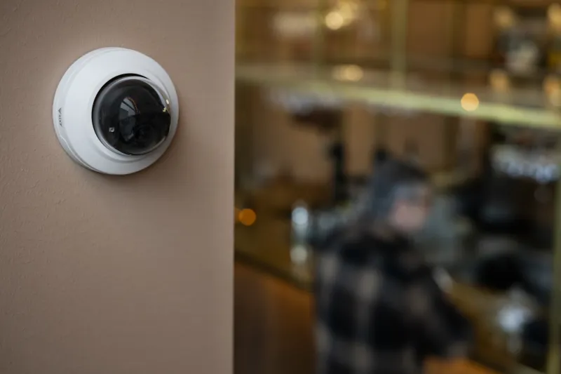 AXIS M3098-LV Dome Camera mounted on wall in front of restaurant 