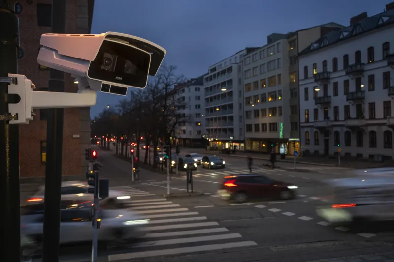 AXIS P1518-LE mounted high in a traffic area in the city during dusk.