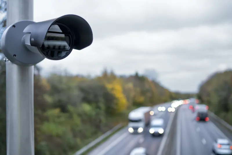 AXIS Q1800-LE mounted on a pole and overlooking a highway.
