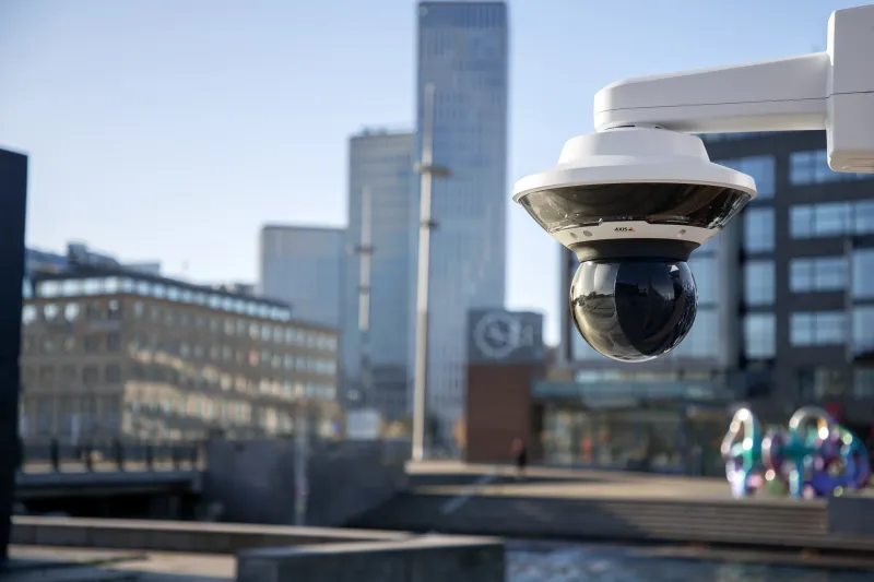 AXIS Q6315-LE and AXIS Q6100-E mounted in the city center by tall buildings and a canal.