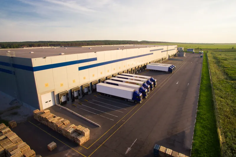 Trucks lined up in loading docks in the sunlight.