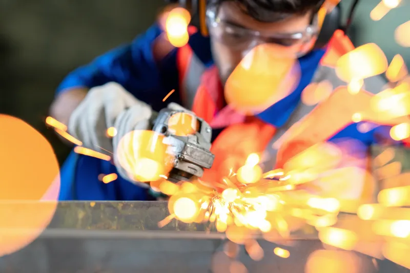 Close up of a industry worker cutting steal with sparks flying.