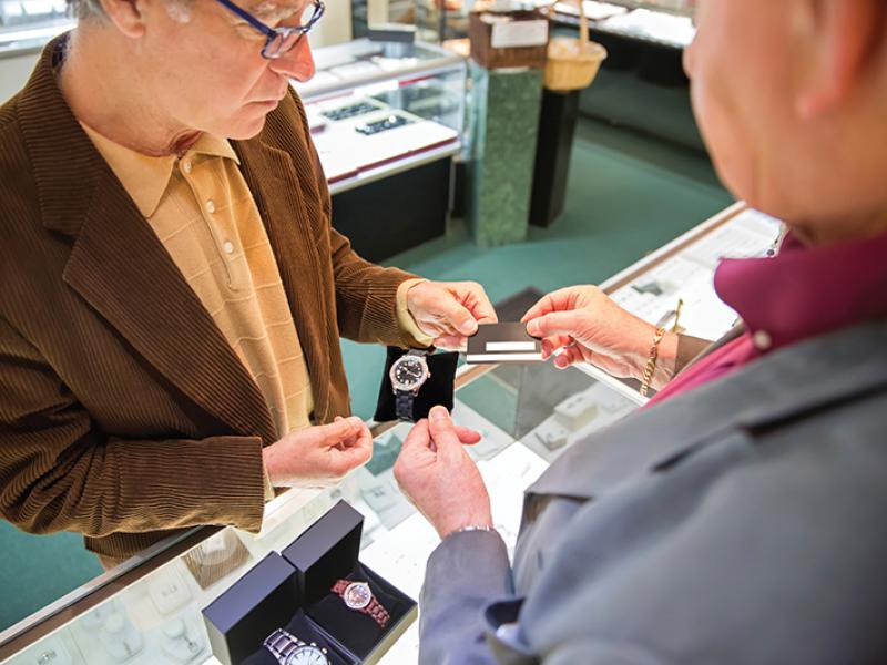 Man buying watch with card at cashier