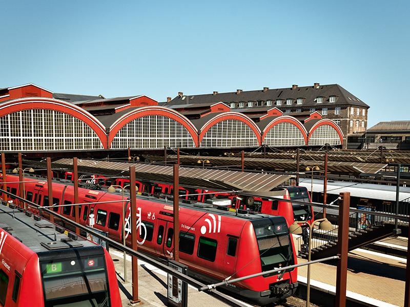 Red trains on station with blue skies