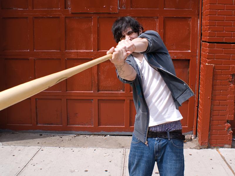 man with baseball bat swinging