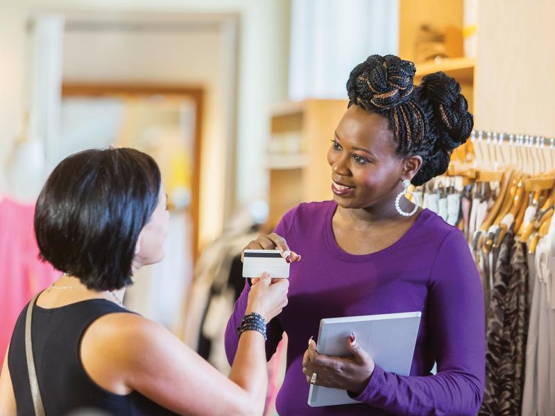 A woman handing over her creditcard to the cashier