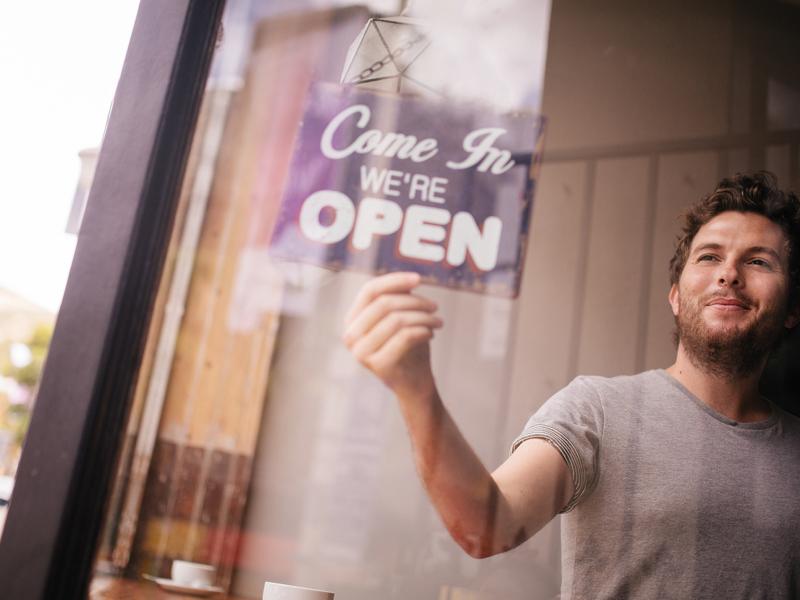 Coffee shop owner turning the open-sign