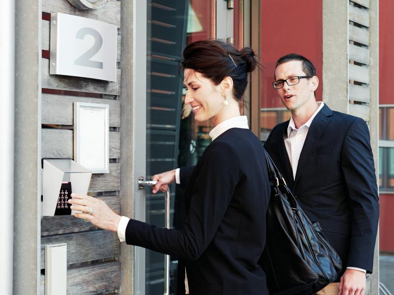 a woman and a man outside a entrance using access control