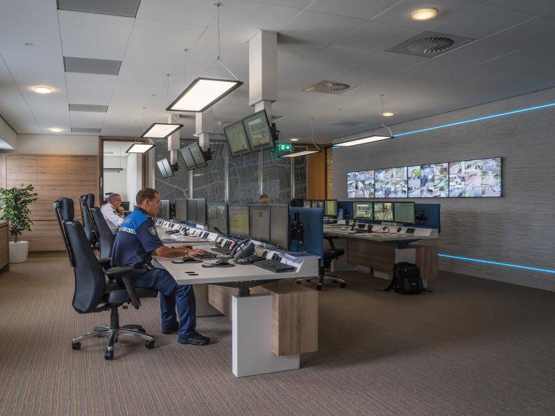 Two men in monitoring room, with multiple screens.