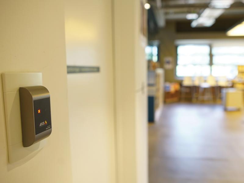 Axis A4010-E reader placed on white wall.