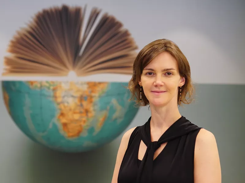 Woman standing in front of a half globe.