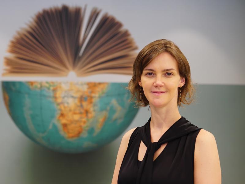 Woman standing in front of a half globe.