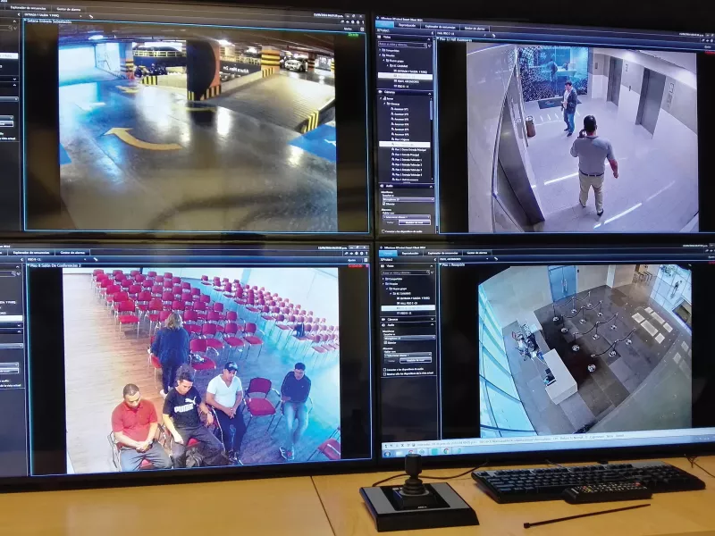 Four computer screens monitoring various rooms.