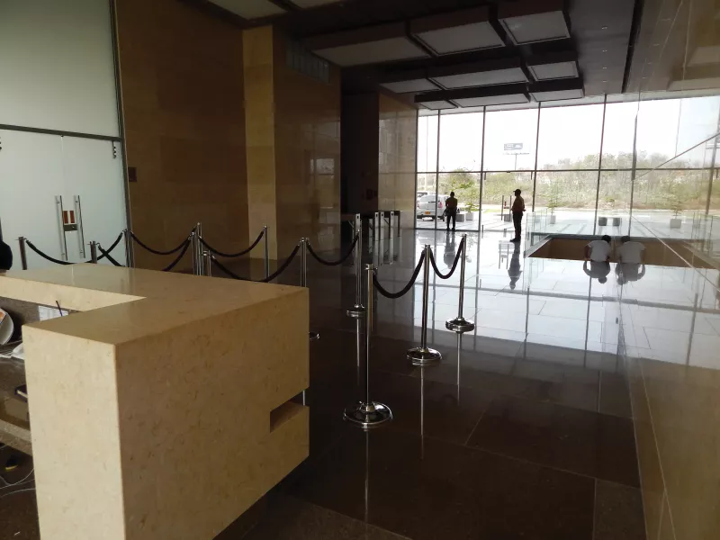 Interior of dark lobby, two people in background.