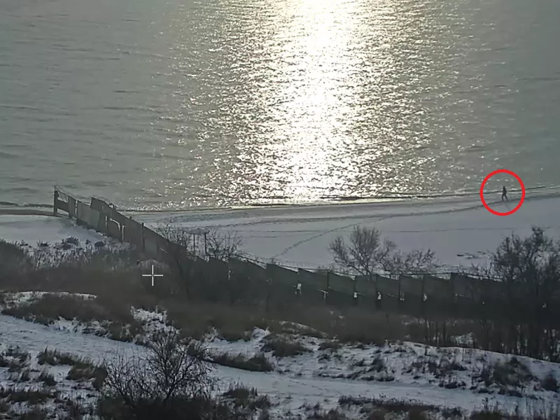 Screenshot of man at the beach, circled with red.