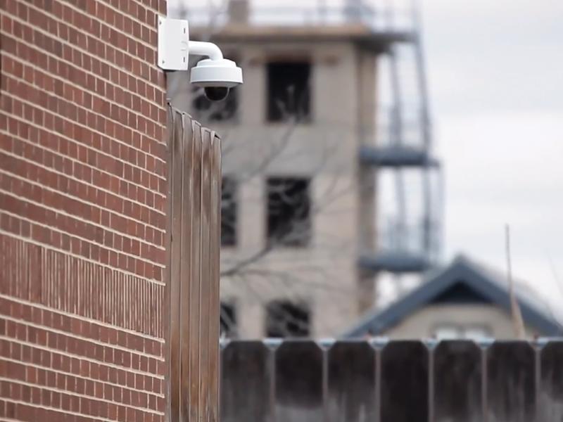 Axis Wall Camera on a brick wall in outdoor environment.