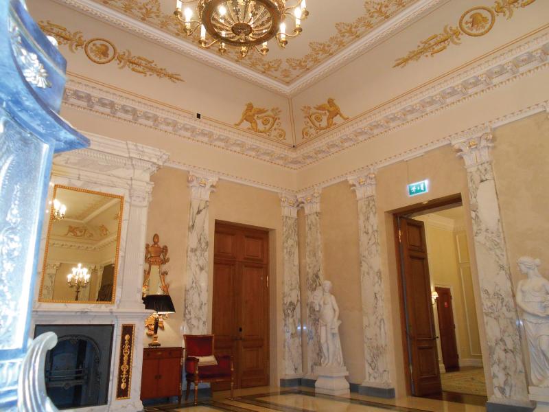 Hotel lobby with white and gold decorated walls and ceiling.