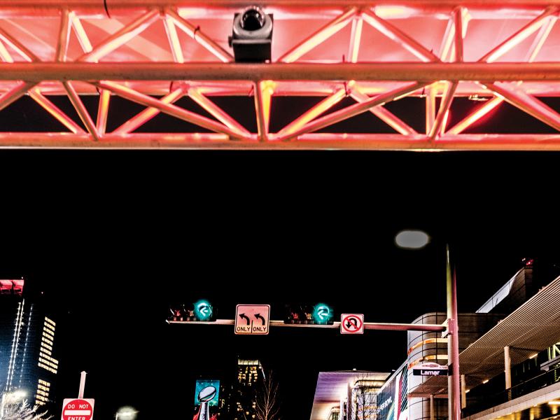 Axis dome camera above street, green traffic light in background.