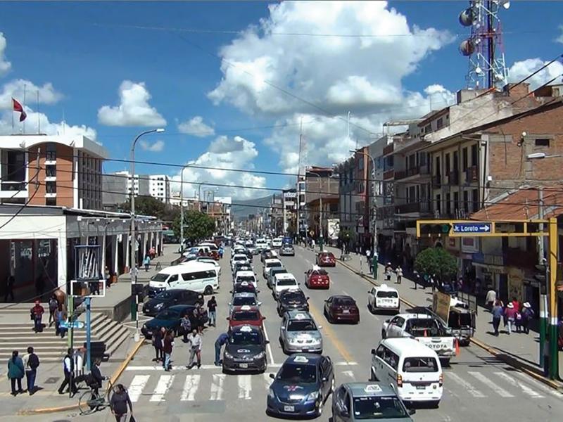 City street with traffic and brown buildings alongside.